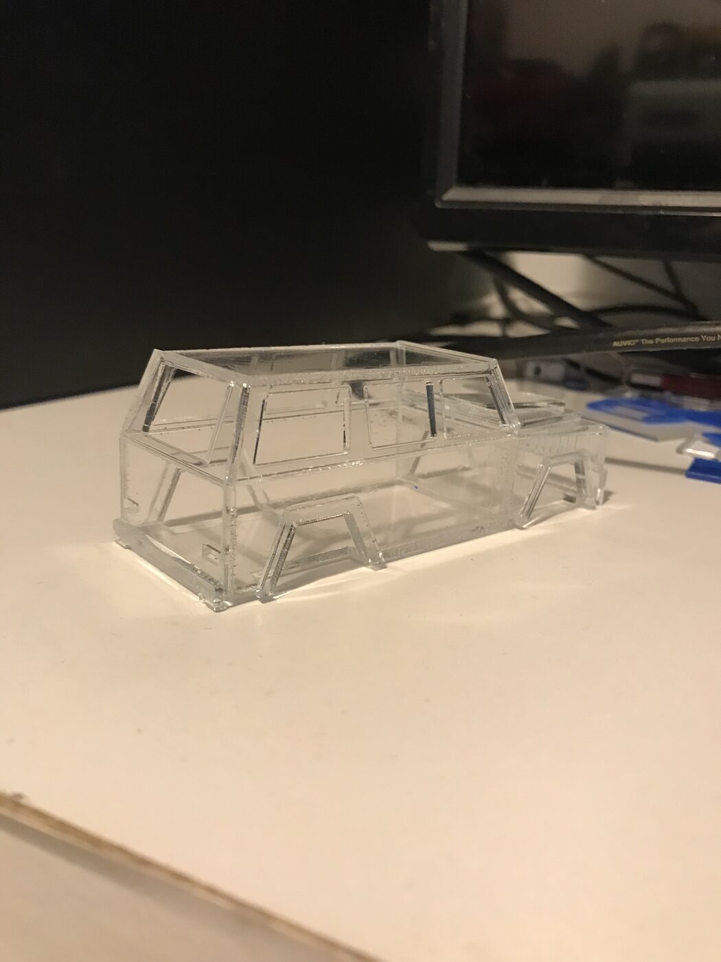 Clear acrylic SUV body on a desk, angled view