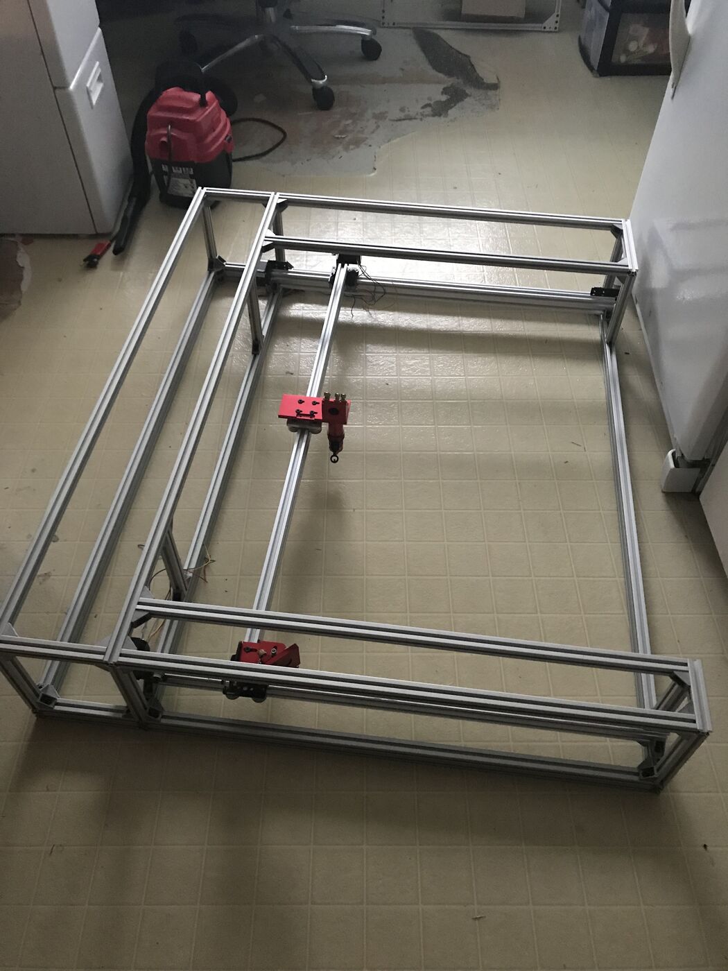 Bare aluminum extrusion frame on a kitchen floor with the laser gantry installed
