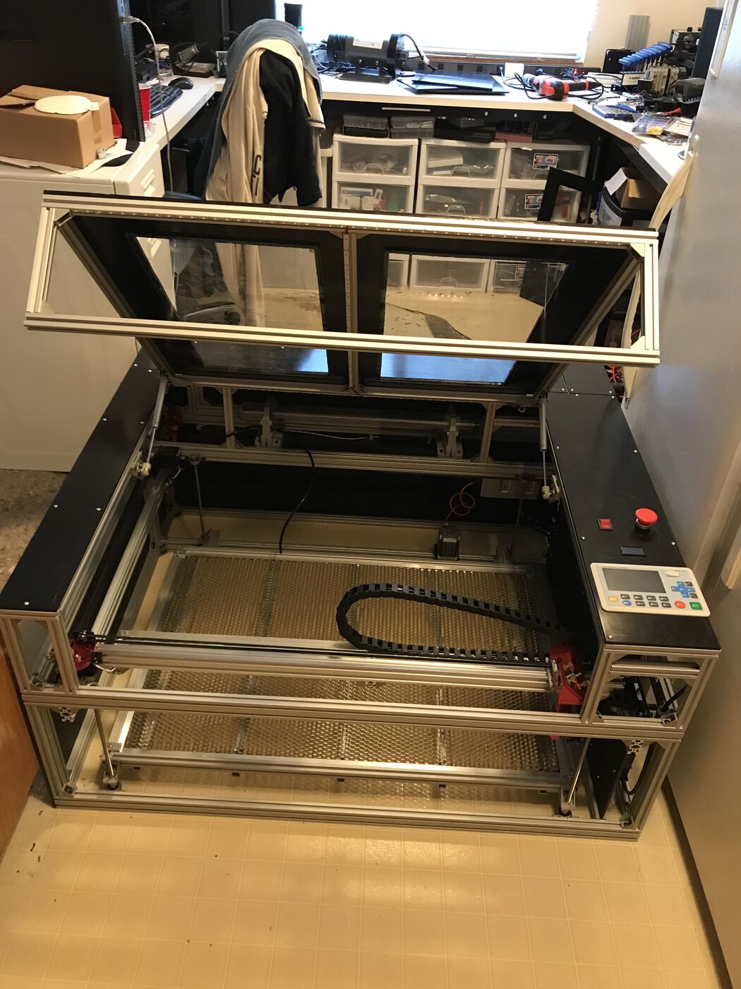 Finished laser cutter with the lid raised and LED strips lit over the honeycomb bed